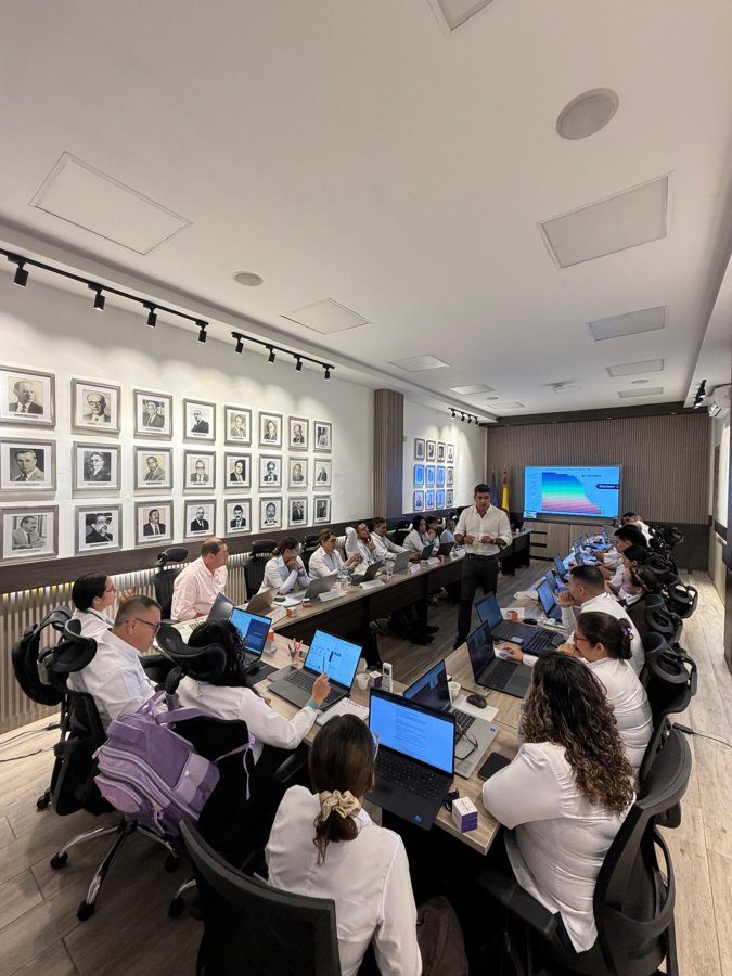 Equipo trabajando con portátiles en una sala de juntas durante un laboratorio de IA